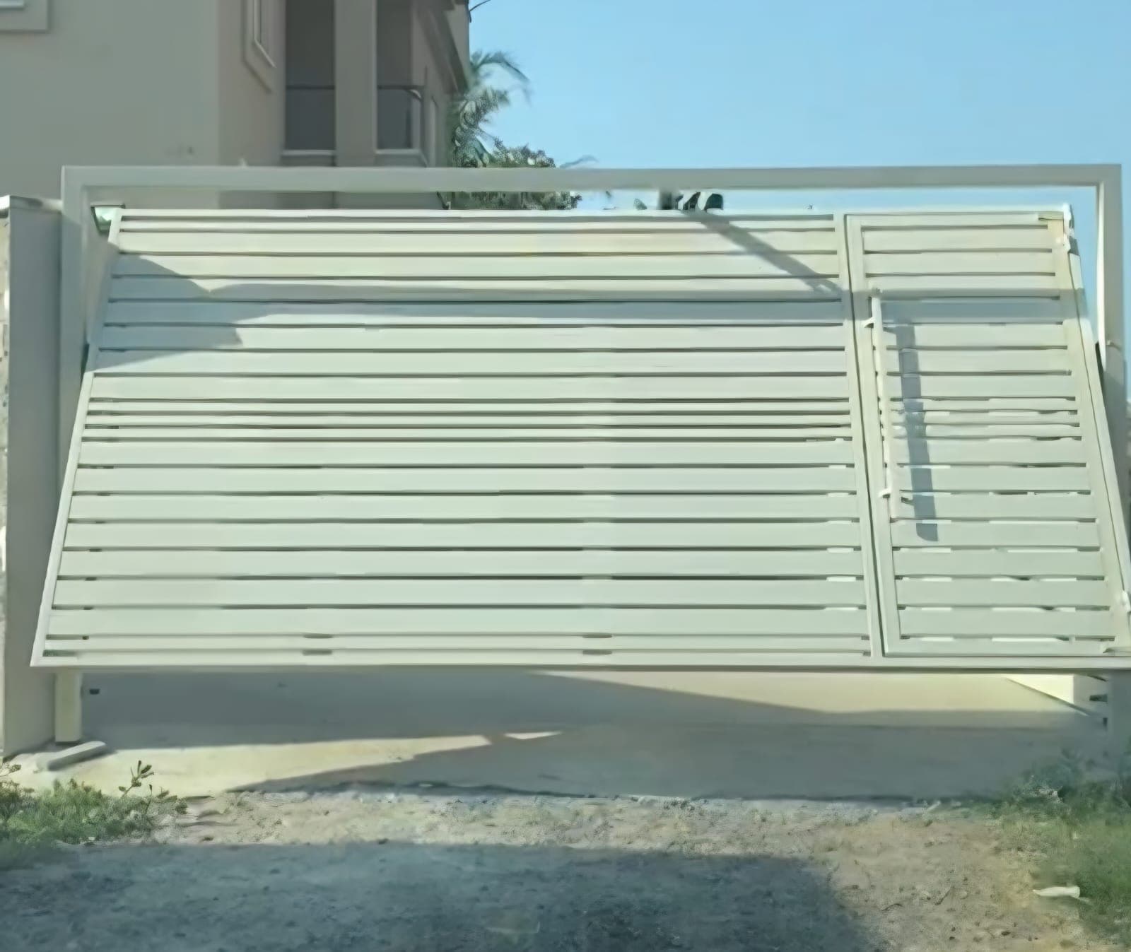 שער כניסה מאלומיניום לבית פרטי עם פשפש להולכי רגל לצד שער רכב